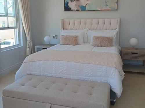 een slaapkamer met een groot bed met een grote witte sprei bij L'Ermitage Villa Francois in Franschhoek