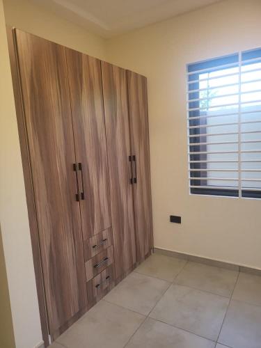 a large wooden door in a room with a window at Property for rent in Accra