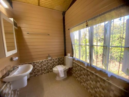 een badkamer met een wastafel en een toilet en een raam bij Elephant House and Pool Villas 