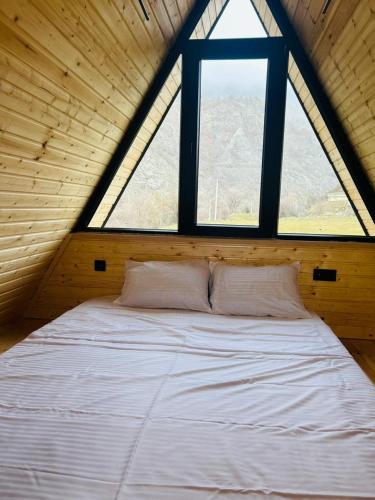 a large bed in a room with a window at smile cottage in Borjomi