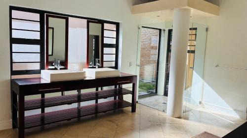 a bathroom with two sinks and a mirror at The Folkestone Guest House in Gqeberha
