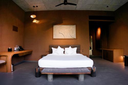 a bedroom with a large bed and a table at Ayana Villa By KPM in Varagampadi