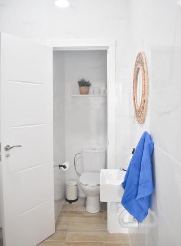 a white bathroom with a toilet and a sink at La Isleta Nest Hostel in Las Palmas de Gran Canaria
