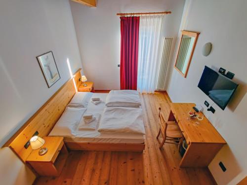 une petite chambre avec un lit et une table dans l'établissement Camping Dolomiti, à Dimaro