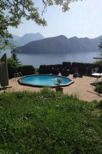 a large swimming pool with a view of a lake at Apartment Mätzli by Interhome in Vitznau