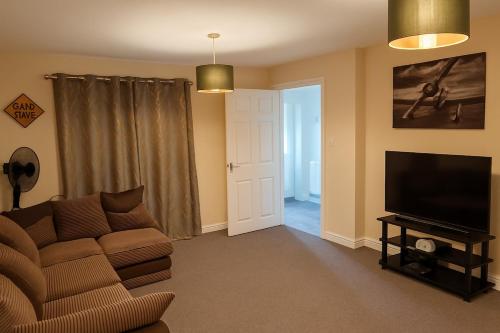 a living room with a couch and a flat screen tv at Cosy House with Garden, 2 Bedrooms in Doncaster