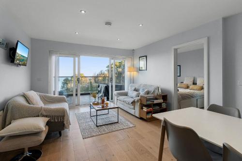a living room with a couch and a table at Avocet 2 Luxury Apartment with Pool and Parking in Brixham