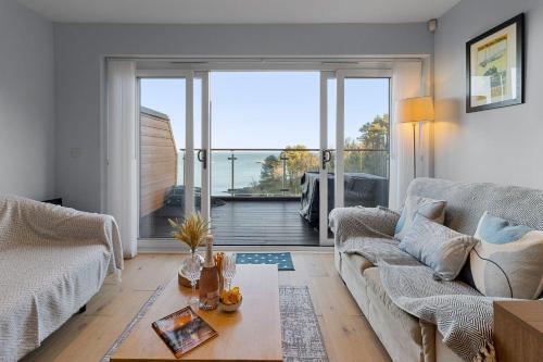 a living room with a couch and a large window at Avocet 2 Luxury Apartment with Pool and Parking in Brixham