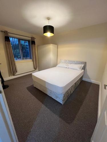 a bedroom with a white bed in a room at Cosy House with Garden, 2 Bedrooms in Doncaster