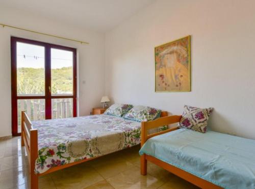 a bedroom with two beds and a window at Villa Marković 2 in Sutomore