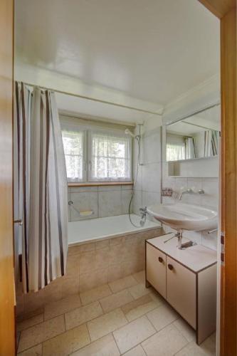 a bathroom with a tub and a sink and a bath tub at Apartment Hautle by Interhome in Eggerstanden - Appenzell