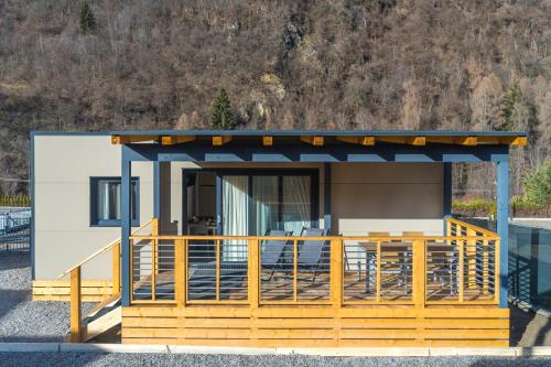 une petite maison avec un porche et une terrasse dans l'établissement Camping Dolomiti, à Dimaro