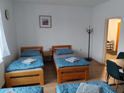 een kamer met drie bedden en een tafel bij Apartmán Opolany in Opolany
