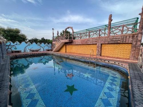 a swimming pool with a star in the water at Pragya Farmhouse in Jodhpur