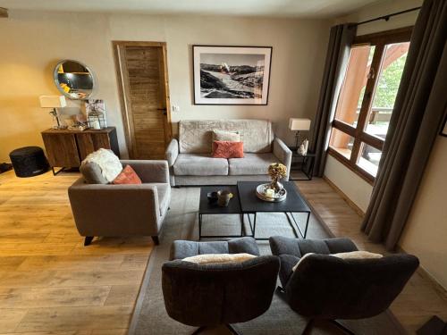 een woonkamer met een bank en een tafel bij Spacious ski-in ski-out renovated apartment 4-6 pax, 161 Sources de Marie Arc 1950 in Arc 1950