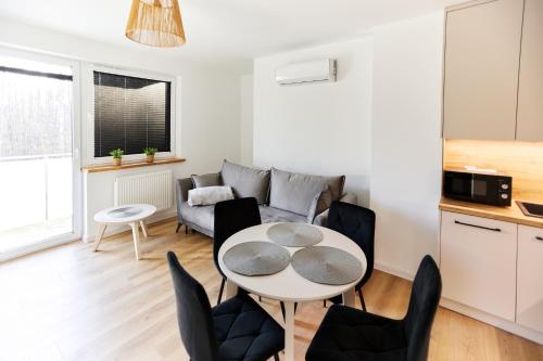 een keuken en een woonkamer met een tafel en stoelen bij Park & Town Apartment in Drawsko Pomorskie
