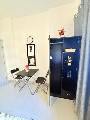 a table and chairs in a room with a clock on the wall at Emira Haven in Abu Dhabi