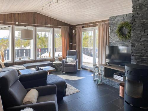 ein Wohnzimmer mit Sofa und Fernseher in der Unterkunft Cabin With Mountain View In Solberglia in Østby