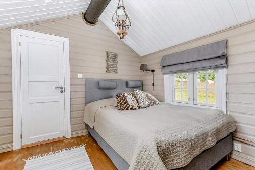 ein Schlafzimmer mit einem Bett und einem Fenster in der Unterkunft Family-Friendly Log Cabin With Panoramic View in Østby