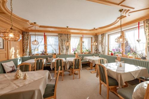 a restaurant with white tables and chairs and windows at Haus Iris in Lech am Arlberg
