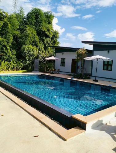 een zwembad met blauw water voor een huis bij Nan poolvilla in Ban Kot