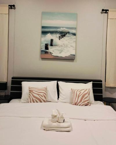 een slaapkamer met een wit bed en een schilderij erboven bij Nan poolvilla in Ban Kot