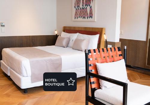 een hotelkamer met een bed en een stoel bij Hotel Palermitano by DOT Boutique in Buenos Aires