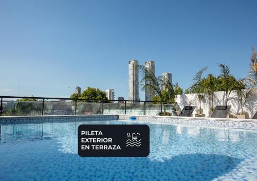 a sign in front of a swimming pool with a city at Hotel Palermitano by DOT Boutique in Buenos Aires