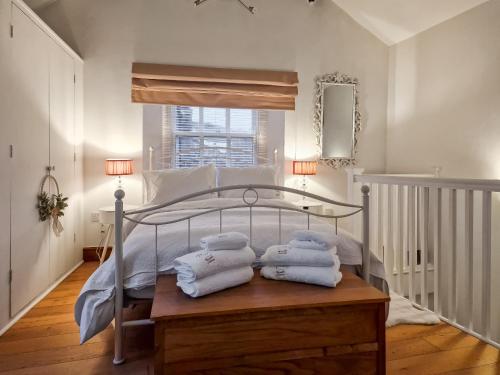 een slaapkamer met een bed met handdoeken op een houten tafel bij Thimble Cottage in St Bees