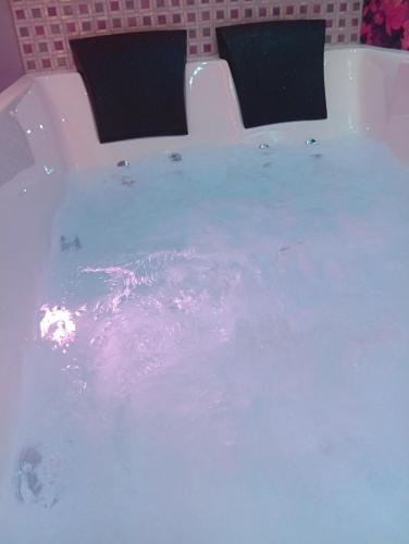 eine mit Wasser gefüllte Badewanne mit zwei Stühlen in der Unterkunft les cités romance le Tokyo in Carcassonne