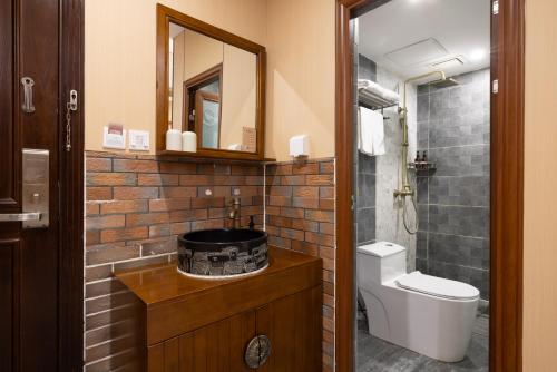 ein Badezimmer mit Waschbecken, Toilette und Spiegel in der Unterkunft The East Hotel--The Forbidden City,Beijing Drum Tower, Nanluoguxiang Hutong, Houhai Bar Street,Beijing's Historic Hutongs in Peking