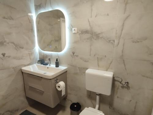 a white bathroom with a sink and a mirror at Old Town in Livno
