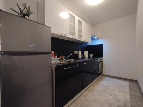 a kitchen with black cabinets and a stainless steel refrigerator at Old Town in Livno