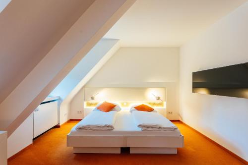 ein Schlafzimmer mit einem weißen Bett auf dem Dachboden in der Unterkunft Heideblick - Tagungs- und Freizeithotel an der Lüneburger Heide in Jesteburg