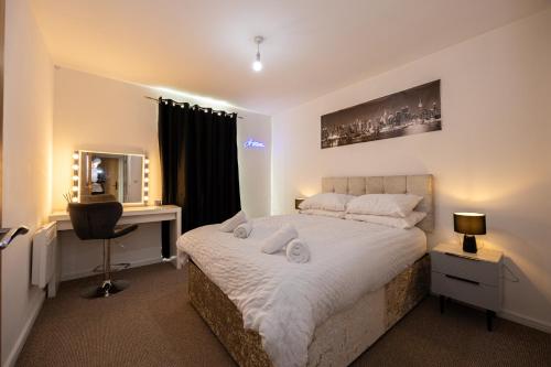 a bedroom with a bed with a desk and a mirror at Cityside Apartment Walk to Etihad & Coop Live in Manchester