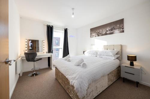 a bedroom with a bed with a desk and a window at Cityside Apartment Walk to Etihad & Coop Live in Manchester