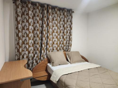 - un petit lit dans une chambre avec rideau dans l'établissement Bright apartment 1 to 3 bedrooms, à Besançon