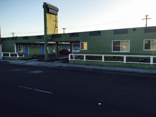 an empty street in front of a green building at Town House Motel in Lynwood