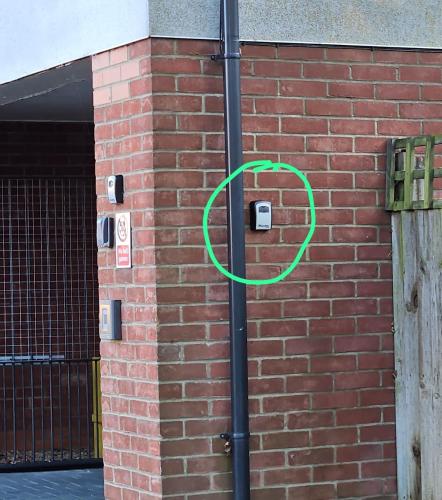 a green circle on a pole next to a brick wall at Lux Den close to M1! Netflix , Parking & Broadband in Milton Keynes