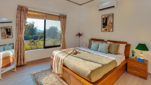 a bedroom with a bed and a large window at SaffronStays Green Lawns in Pāli
