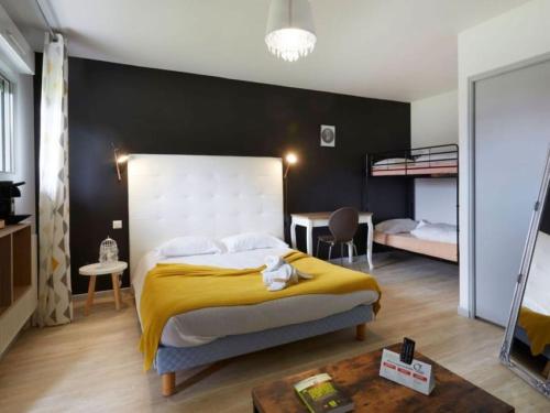 ein Schlafzimmer mit einem großen Bett mit einer gelben Decke in der Unterkunft Logis Hotel- Restaurant La Haie Des Vignes Séminaires et Evènementiel in Allain