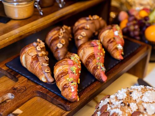 Un montón de salchichas y croissants en una bandeja en Sofitel Luxembourg Europe, en Luxemburgo