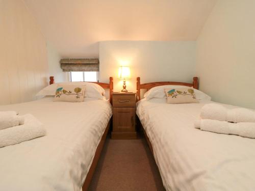 two twin beds in a room with a window at Beacon Cottage in Pickering