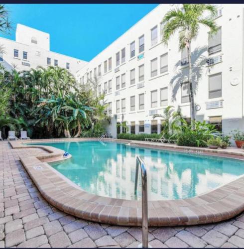 a swimming pool in front of a building at TROPICAL Palm Beach NEW SUITE 3 Beds 2 BEDRS &2BATHROOMS ENSUITE BEACH 5 MINOutdoorPOOL Garden in Palm Beach