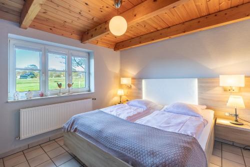 una camera da letto con un letto con due lampade e una finestra di Schipp Landen Frida a Schobüll
