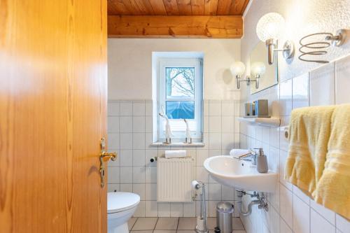 een badkamer met een wastafel en een toilet en een raam bij Schipp Landen Johanna in Schobüll