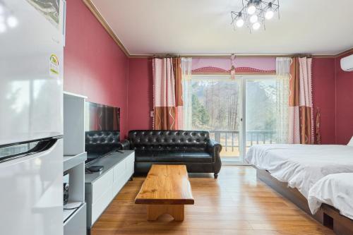 a bedroom with a bed and a couch and a table at Heidi Korea in Hongcheon