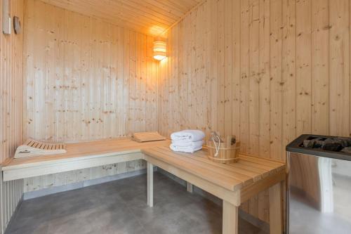 a sauna with a wooden bench in a room at De Bööi - Luxus-Haus mit Meerblick, Sauna & Kamin in Fehmarn