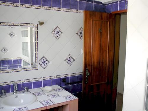 un bagno con lavandino e specchio di Quinta das Achadas - Quartos a Cerro Ruivo
