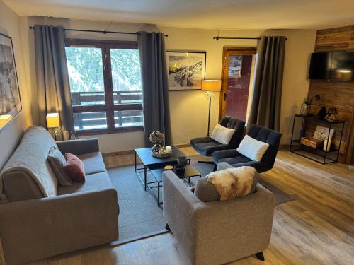 een woonkamer met twee banken en een tafel bij Spacious ski-in ski-out renovated apartment 4-6 pax, 161 Sources de Marie Arc 1950 in Arc 1950
